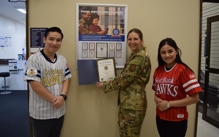 Stars and Stripes Pacific Commander Col. Marci Hoffman presents Best Cellphone Provider BOP award to Softbank staff.
