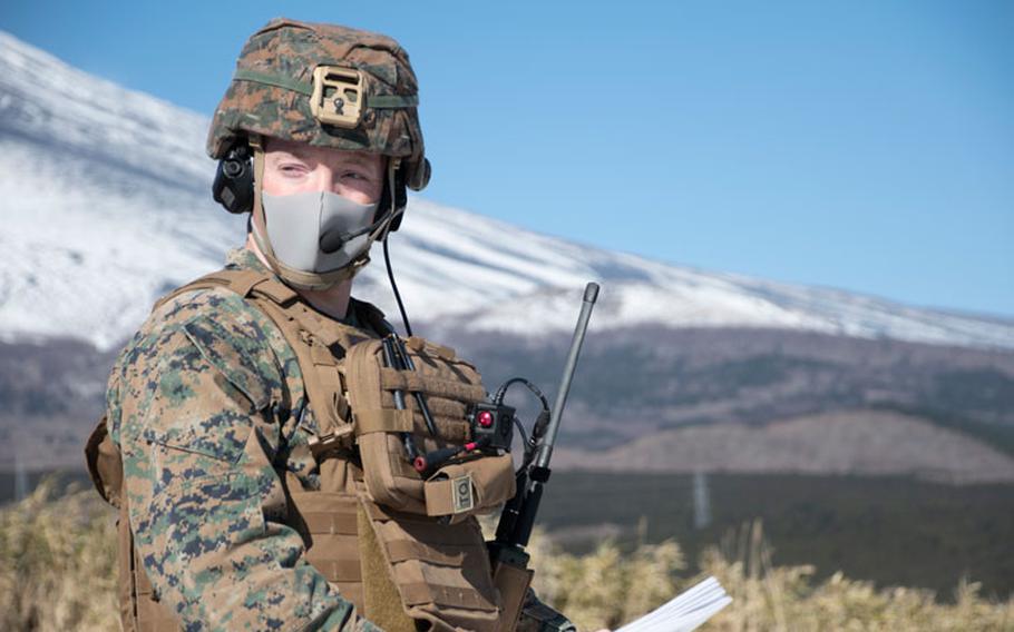 A U.S. Marine relays information to onlookers while observing fixed wing close air support training at Combined Arms Training Center Camp Fuji, Japan, Jan. 14.