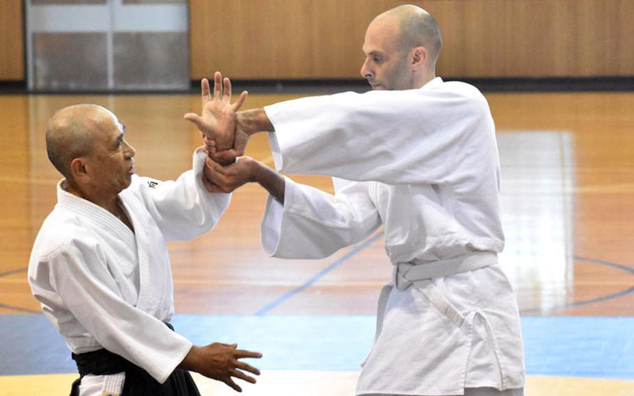 Yotaro Mukai, left, aikido sensei at the Yano Fitness Center, works with Geoff Ward, an engineer with the U.S. Army Corps of Engineers, Japan Engineer District, during an aikido class at the Yano Fitness Center, Camp Zama, Japan, Aug. 8. (Photo Credit: Wendy Brown, U.S. Army Garrison Japan Public Affairs)