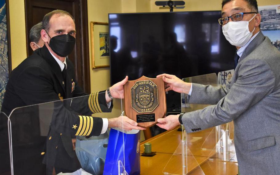 Capt. Warren Smith, Commanding Officer aboard Ticonderoga-class guided-missile cruiser USS Antietam (CG 54), left, exchanges gifts with The Honorable Toshiya Hazama, Mayor of Otaru, right, during a meeting at Otaru Town Hall. Antietam is underway conducting routine operations increasing war fighting readiness and increasing ally interoperability. (U.S. Navy photo by Ensign William Stricklett)