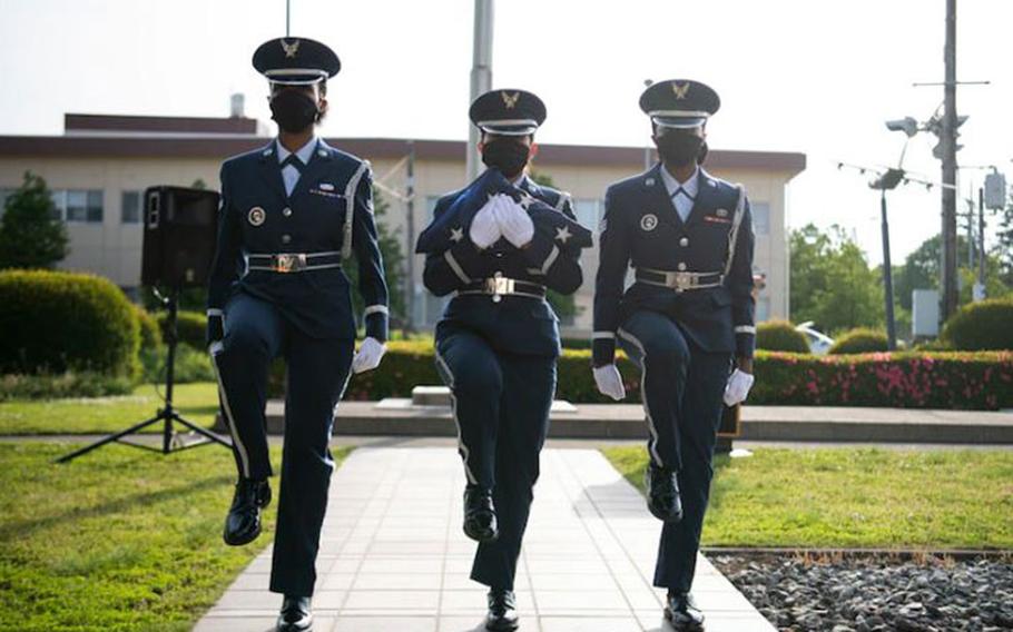 Base honor guard members march with the American flag during the National Police Week retreat ceremony at Yokota Air Base, Japan, May 14, 2021. The retreat ceremony featured speeches, the lowering of the American and Japanese flags and a bell ringing to signify the end of watch for fallen law enforcement. (U.S. Air Force photo by Staff Sgt. Braden Anderson)