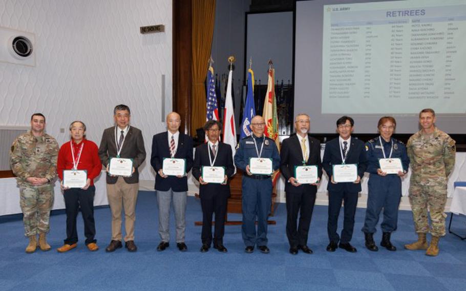 Col. Marcus Hunter, far right, U.S. Army Garrison Japan commander, and Command Sgt. Maj. David A. Rio, far left, garrison senior enlisted leader, recognize several employees who are retiring after decades of service during a workforce town hall at Camp Zama, Japan.