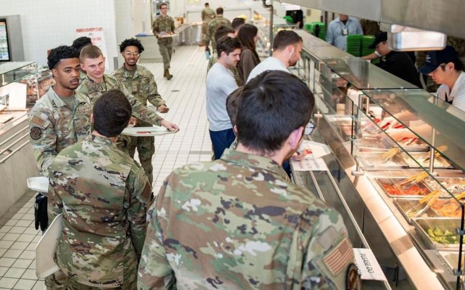 Patrons socialize while waiting in line for their meals at the Yokota Air Base, Japan, dining facility.
