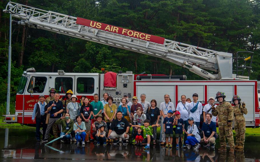 U.S. Air Force Airmen assigned to the 35th Civil Engineer Squadron fire department pose with Misawa Friendship Tour participants at Misawa Air Base, Japan, July 19, 2024.