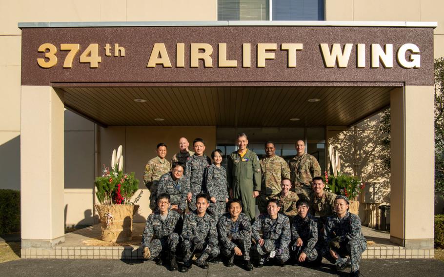 The U.S. Air Force 374th Airlift Wing and Japan Air Self-Defense Force Operational Support Wing members pose for a photo at Yokota Air Base, Japan, Dec. 16, 2022. Every year, JASDF members present Kadomatsu, which are pine and bamboo decorations placed in front of buildings during the New Year holiday to bring health, happiness and prosperity. (U.S. Air Force photo by Staff Sgt. Braden Anderson)