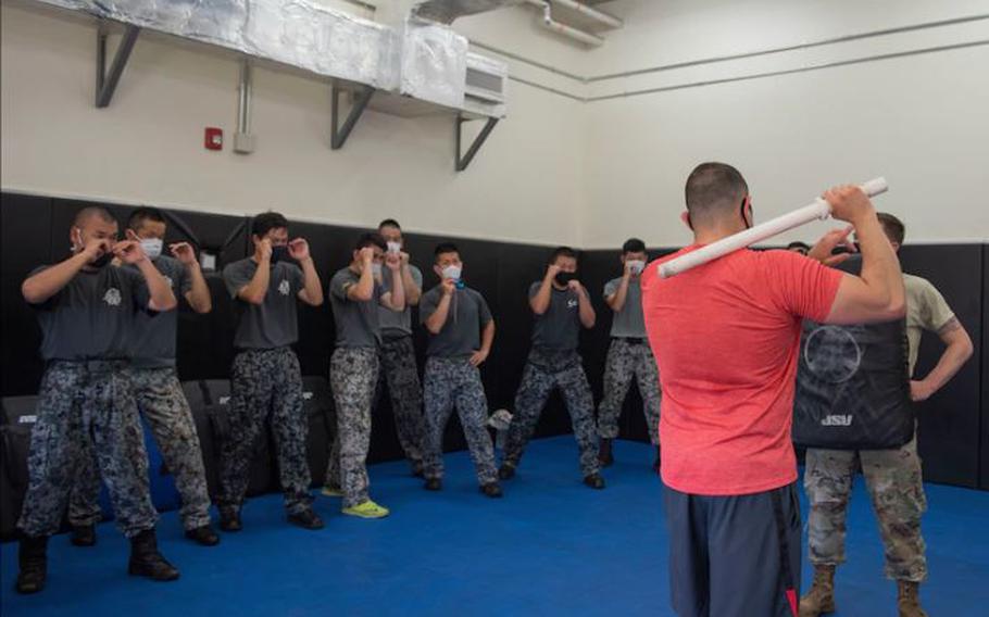 Staff Sgt. Joshua Cordova, 374th Security Forces Squadron flight sergeant, demonstrates a baton technique to Koku-Jieitai (Japan Air Self-Defense Force) members during the bilateral aircraft security training at Yokota Air Base, Japan, August 7, 2020. Koku-Jieitai Security personnel from across Japan took part in the bilateral training event with the 374th SFS. (U.S. Air Force photo by Machiko Airta)