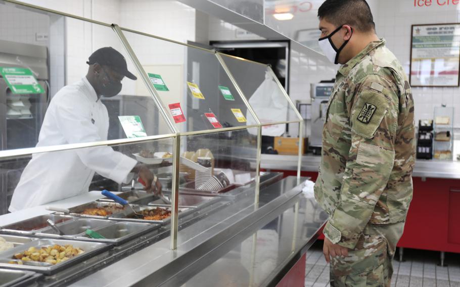 Staff Sgt. Ricardo Morales, right, assigned to the 311th Military Intelligence Battalion, orders lunch Jan. 26 at the dining facility at Camp Zama, Japan. Serving him is a member of the 35th Combat Sustainment Support Battalion’s field feeding platoon. When services at the dining facility were interrupted Jan. 21, the field feeding platoon took over operations and began providing hot, takeout-only meals to customers three times a day, seven days a week.