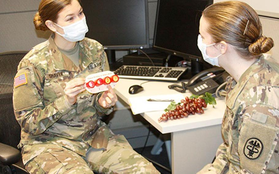 Army 1st Lt. Caitlyn Shaver and Army 1st Lt. Brittany Powers, dietetic interns at Walter Reed National Military Medical Center, role play a nutrition consultation as part of their training in Phase 2 of the U.S. Military-Baylor Graduate Program in Nutrition at WRNMMC (Photo by: Bernard Little, Walter Reed National Military Medical Center).