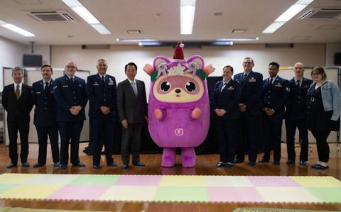 Photo Of Members from the 374th Maintenance Group, Hiroyuki Sugiura, Mizuho town mayor, and Katsumi Oi, Mizuho superintendent of education, pose for a photo with the Mizuhomari, the town’s mascot, during the annual Mizuho Toy Drive at the Musashino Community Center, Tokyo, Japan, Dec. 18, 2024.