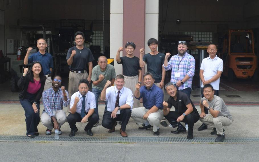 Employees pose for a group photo with Logistics Readiness Center-Honshu director Sean Mager (center, front) at Kawakami Ammo Depot.