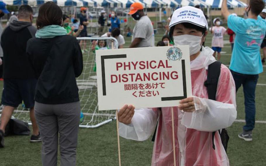 A volunteer displays a physical distancing sign during the Kanto Plains Special Olympics at Yokota Air Base, Japan, May 22, 2021. All participants were reminded to remain as distant as possible in accordance with health and safety guidelines. (U.S. Air Force photo by Airman 1st Class Tyrone Thomas)