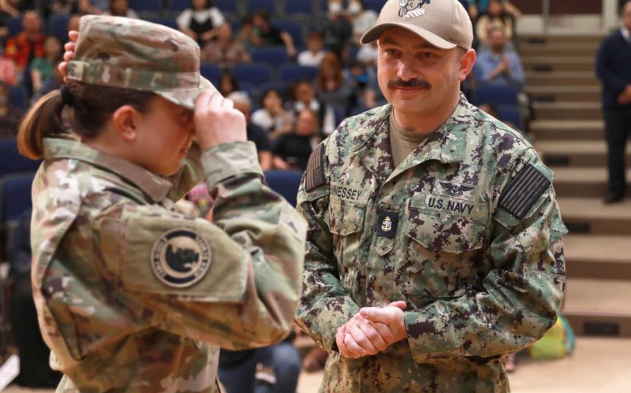 Navy Chief Joseph Fennessey looks on after helping promote his daughter, Liliana Fennessey, to the rank of cadet second lieutenant during the end-of-year ceremony for the Junior Reserve Officers’ Training Corps cadets of Zama Middle High School’s Trojan Battalion, held Friday at the school auditorium. (Dustin Perry, U.S. Army Garrison Japan Public Affairs)