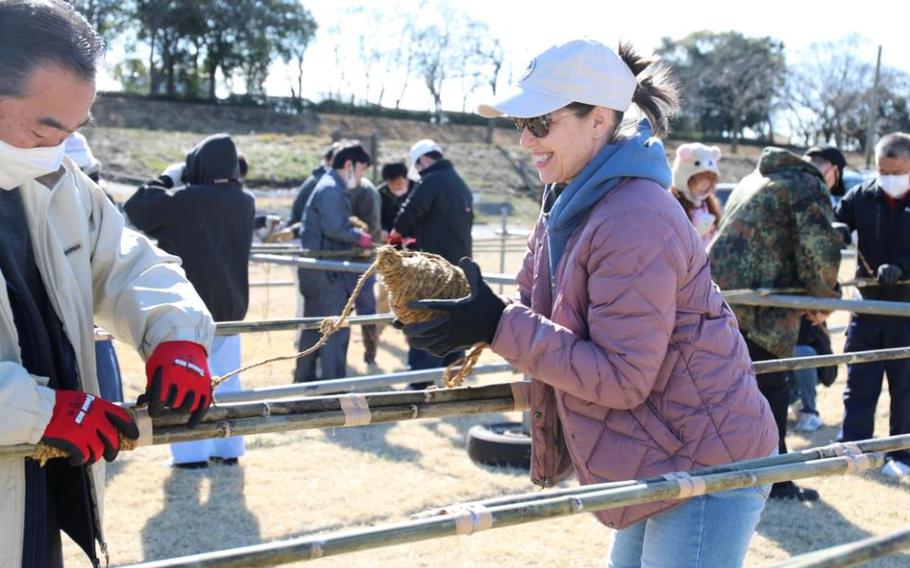 Amy Nulik, right, helps a Japanese staff member wrap a rope around a bamboo kite frame on the banks of the Sagami River March 3.