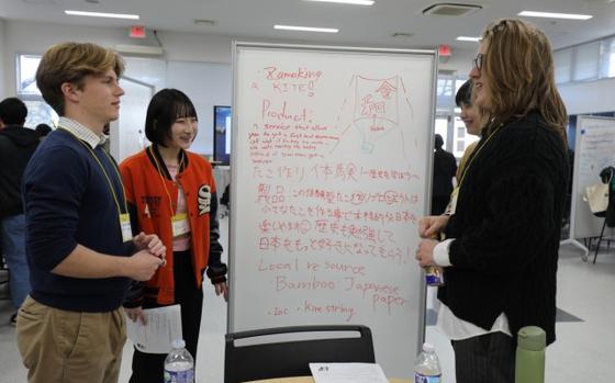 Carson Hansen, left, a junior at Zama Middle High School, discusses a project with his teammates during the student educational exchange and dialogue event, or SEED, Dec. 15 at Zama Middle High School.