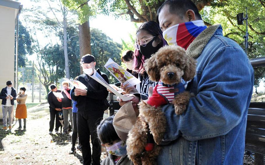 Joey Escalante holds Kou’na, a toy poodle, during the Holy Family Catholic Community St. Francis Blessing of the Pets and Animals, Camp Zama, Japan, Oct. 31.