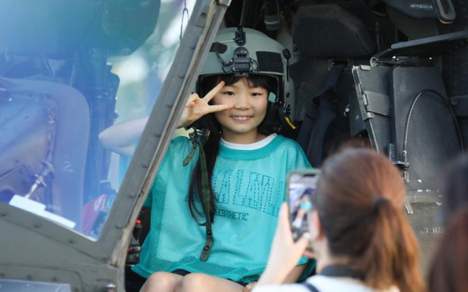 A young girl poses for a photo while inside a UH-60 Black Hawk helicopter on display during an Independence Day celebration at Camp Zama, Japan, June 29, 2024.