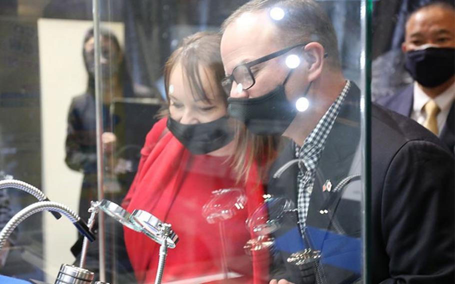 Col. Christopher L. Tomlinson, right, U.S. Army Garrison Japan commander, right, and his wife, Amaya, left, view samples from the asteroid “Ryugu” during an exhibition tour at the Sagamihara City Museum Dec. 8. The spacecraft Asteroid Explorer Hayabusa2 collected the samples from space and returned them to Earth during a six-year mission. (Photo Credit: Noriko Kudo)