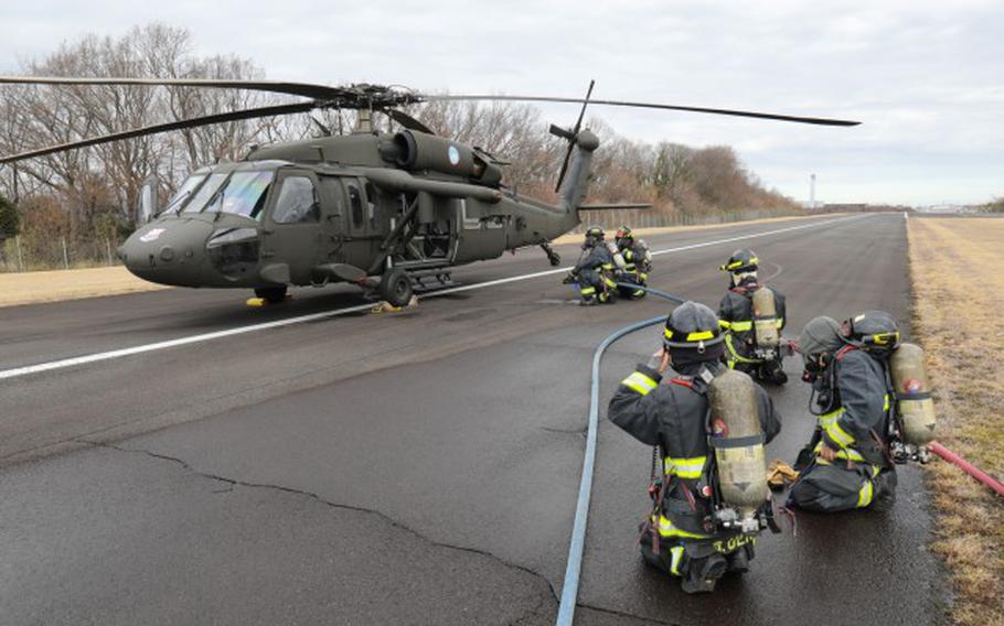 U.S. Army Garrison Japan firefighters extinguish a mock fire on a UH-60 Black Hawk helicopter as part of a downed aircraft exercise at Camp Zama, Japan, March 7, 2024. Firefighters also evacuated the aircrew to a nearby safe location and used radio communication to coordinate their efforts with the air traffic control tower.