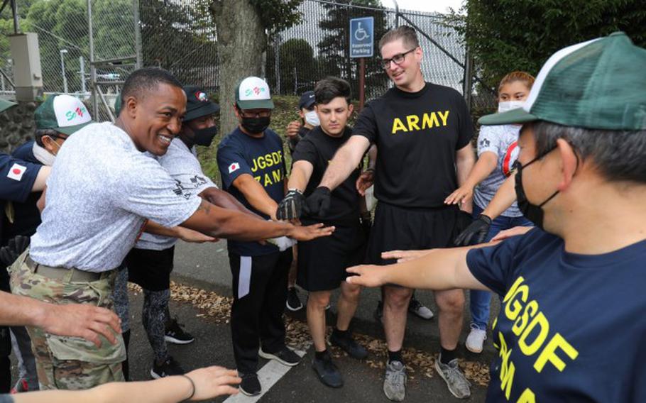 Command Sgt. Maj. Justin E. Turner, left, senior enlisted leader for U.S. Army Garrison Japan, huddles with participants following a beautification project outside the main gate of Camp Zama, Japan, July 8, 2022. More than 20 U.S. Soldiers and Japanese counterparts conducted the cleanup that also aimed to strengthen their partnership. (Photos Credit: Sean Kimmons)