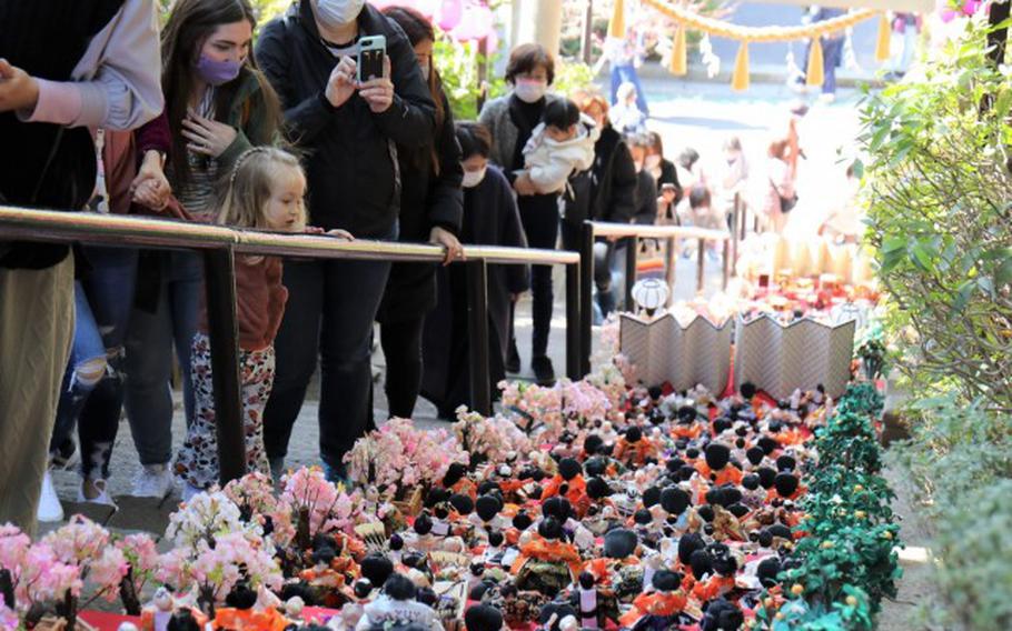 Participants of a walking tour held by Army Community Service admire "Hina" dolls as they go up the stairs to the Zama Shrine, Japan, March 1, 2022. Every year, shrines across Japan attract crowds by allowing parents to display intricate dolls that represent their daughters as they pray for their growth and happiness. (Sean Kimmons)