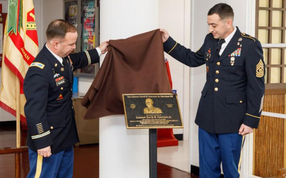 Col. Christopher L. Tomlinson, left, commander of U.S. Army Garrison Japan, and Command Sgt. Maj. David A. Rio, the garrison's senior enlisted leader, unveil a plaque during a ceremony to rename the garrison's headquarters building at Camp Zama, Japan, April 5, 2023. The building, commonly referred to as Building 102 or the Garrison building, is now named the Col. David B. Hannum Jr. Garrison Headquarters Building in honor of the former garrison commander. (Photo Credit: Momoko Shindo)