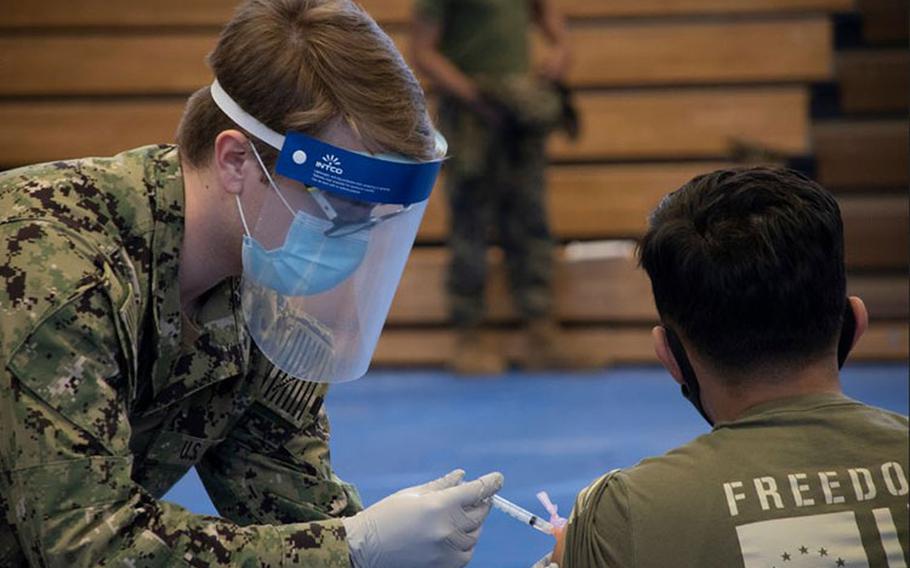 U.S. Navy sailor prepares a Marine for their first dose of the Moderna COVID-19 vaccine, Gotemba, Japan, Feb. 18.