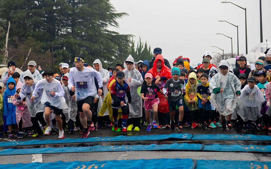 Runners cross the start line to begin the 2K family and kids run during the 43rd Annual Frostbite Road Race at Yokota Air Base, Jan. 21, 2024. The race was hosted by the Yokota Striders Running Club, a local non-profit organization that aims to connect the local community on and off-base through physical fitness. (U.S. Air Force photo by Airman 1st Class Alexzandra Gracey)