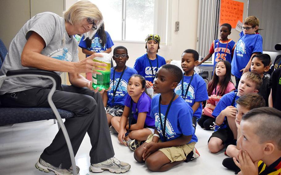 Malinda Martin, a volunteer, uses science to illustrate a point about the Bible story of the Good Samaritan during Vacation Bible School at Camp Zama, Japan, July 31. (Photo Credit: Wendy Brown, U.S. Army Garrison Japan Public Affairs)