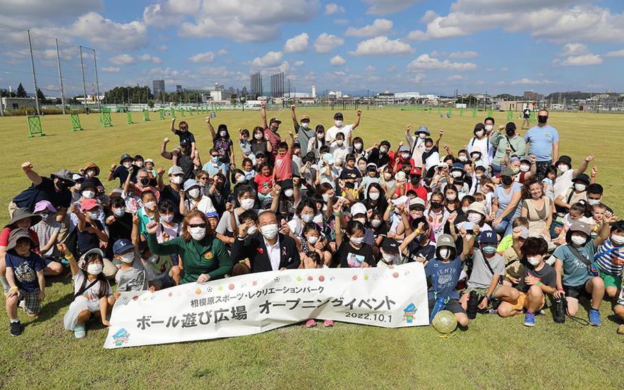 Jenifer Peterson, deputy garrison commander for U.S. Army Garrison Japan, and Sagamihara City Mayor Kentaro Motomura, both in the front row, pose for a group photo with children who participated in a friendship event Oct. 1 at the opening of a new multipurpose sports field located next to the Army’s Sagami General Depot. Photo by Noriko Kudo