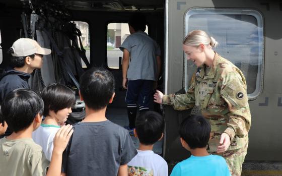 Photo Of Chief Warrant Officer 2 Mckenzie Patangan, right, a helicopter pilot assigned to U.S. Army Aviation Battalion Japan, introduces a group of local Japanese children to a UH-60 Black Hawk helicopter at Camp Zama, Japan, Sept. 23, 2024.