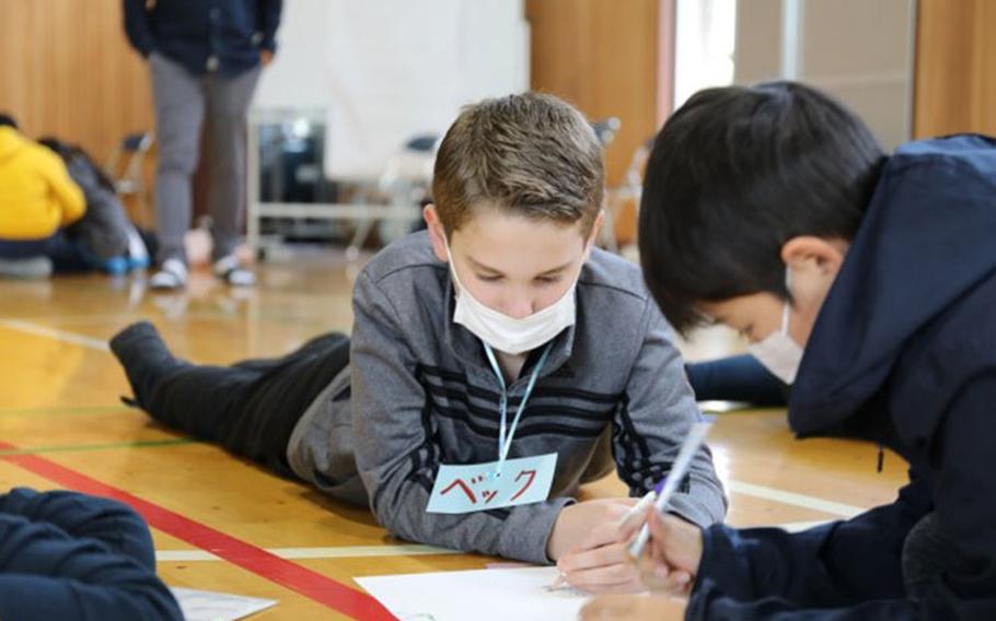 Students from Arnn Elementary School and Kurihara Elementary draw together during a cultural exchange program held Nov. 9 at Kurihara, near Camp Zama, Japan.