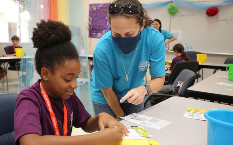 Bryanna Nelson, right, teaches Sinnye Wynn, 11, how to create a journal as part of an arts and crafts project during a Vacation Bible School at Camp Zama, Japan, Aug. 9, 2022. More than 140 children from the Army community participated in the annual program, which provided children the chance to play with friends while learning a variety of religious lessons. (Photo Credit: Nanaka Wada)