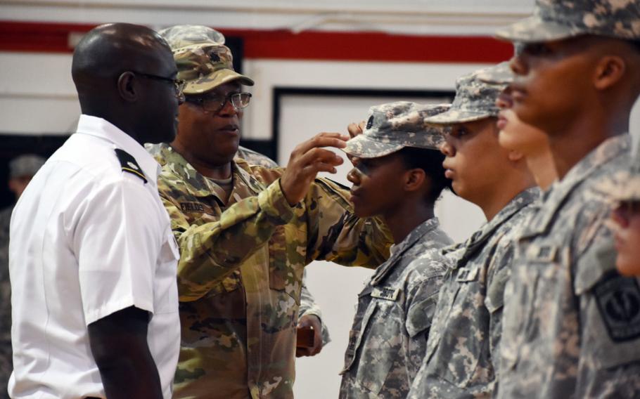 Retired Lt. Col. Douglas Fields, senior Army instructor for the Junior Reserve Officers’ Training Corps at Zama Middle High School, promotes Queen Thomas, a sophomore at the school, to the rank of cadet master sergeant during a promotion ceremony at Camp Zama, Japan, Oct. 3, 2019. Thomas’ father, Lt. Col. Demetrick Thomas, right, commander, 35th Combat Sustainment Support Battalion, looks on.