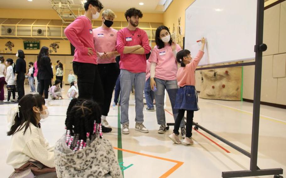 A child draws a picture with a help of Keystone Club members, which falls under Camp Zama’s Boys and Girls Club of America, during a cultural exchange event held Feb. 25 at the Youth Center on Camp Zama, Japan. Photo by Noriko Kudo