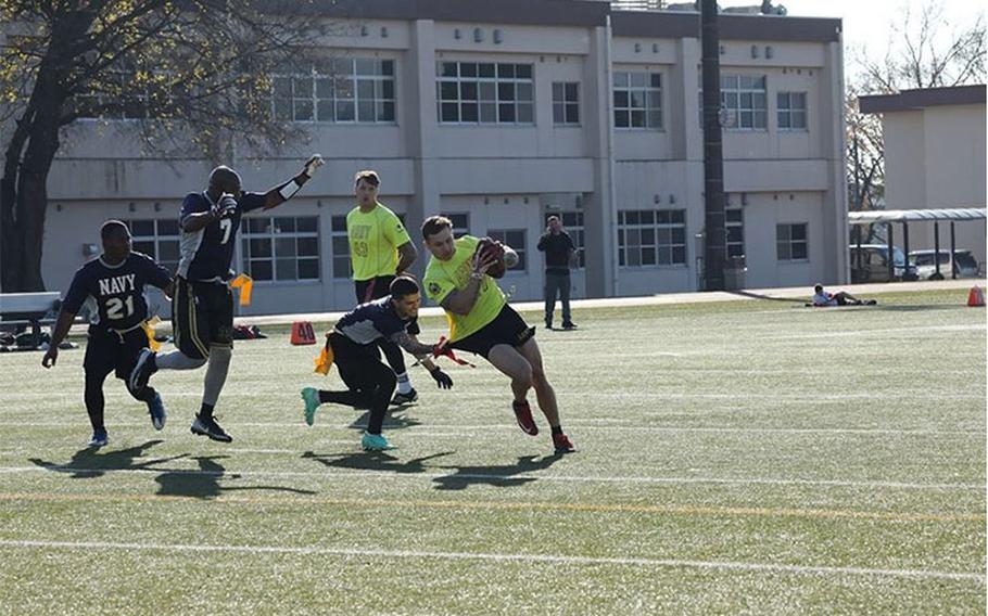 Army player Brett Lawrence has his flag pulled away by a Navy defender during the annual Army-Navy flag football game Dec. 11 at Zama Middle High School’s Trojan Field at Camp Zama, Japan. Camp Zama’s Army team defeated Naval Air Facility Atsugi 13-6, extending the winning streak they’ve maintained since 2016. (Photo Credit: Noriko Kudo)