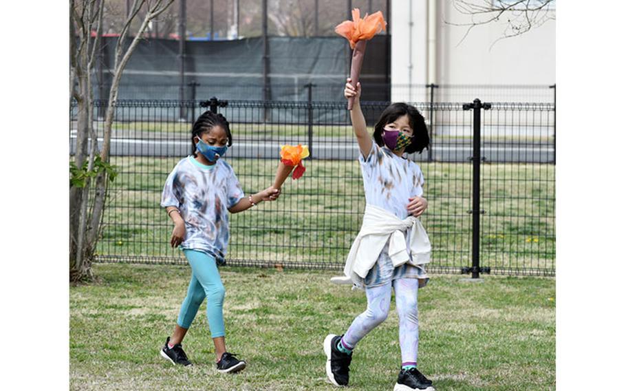 Emma Owen, right, and Cymone Vaughn, second-graders, participate in the opening ceremony of the 2021 School Age Center Olympics at Sagamihara Family Housing Area, Japan, April 1.