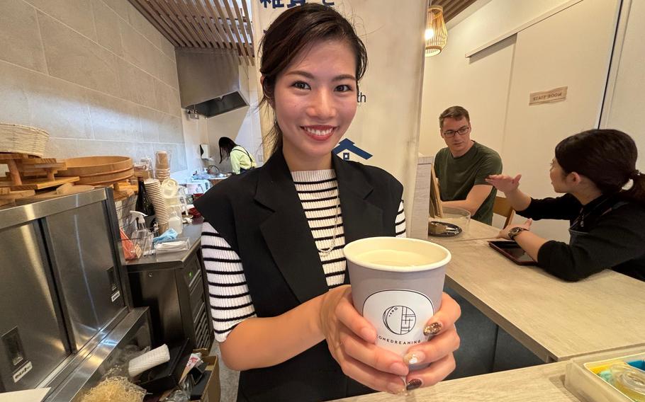 staff holding a cup of amazake