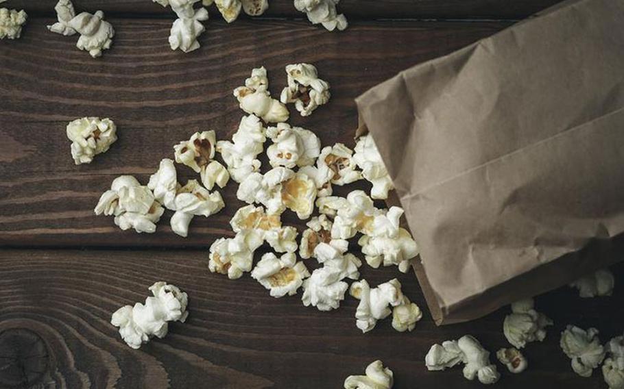 Popcorn in paper bag on wooden table