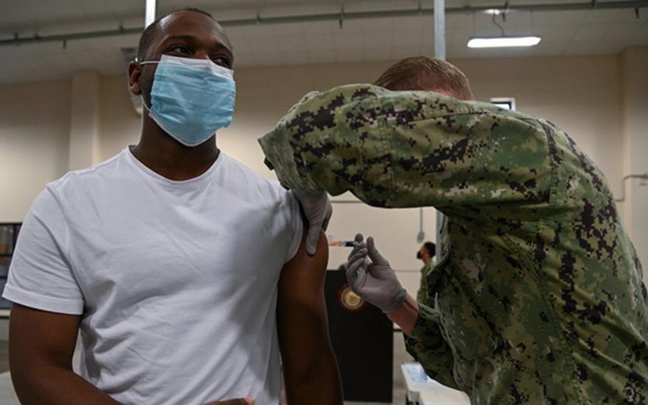 Hospital Corpsman 3rd Class Peter Warren (right) administers an influenza vaccination to Air Force Airman First Class Zachery Mamon as part of a seasonal shot exercise onboard Naval Air Station Sigonella, October 29, 2020. (U.S. Navy photo by Mass Communication Specialist Seaman Triniti Lersch)