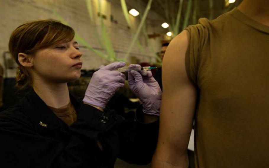 Hospital Corpsman 3rd Class Kindal Kidd, from Neodesha, Kansas, assigned to USS Gerald R. Ford's (CVN 78) medical department, administers a flu shot to a sailor in the ship's hangar bay. Ford's medical department is vaccinating the entire crew against the flu virus to ensure the crew remains medically ready as the ship prepares to go out to sea. (Photo: U.S. Navy Mass Communication Specialist Seaman Apprentice Angel Thuy Jaskuloski)