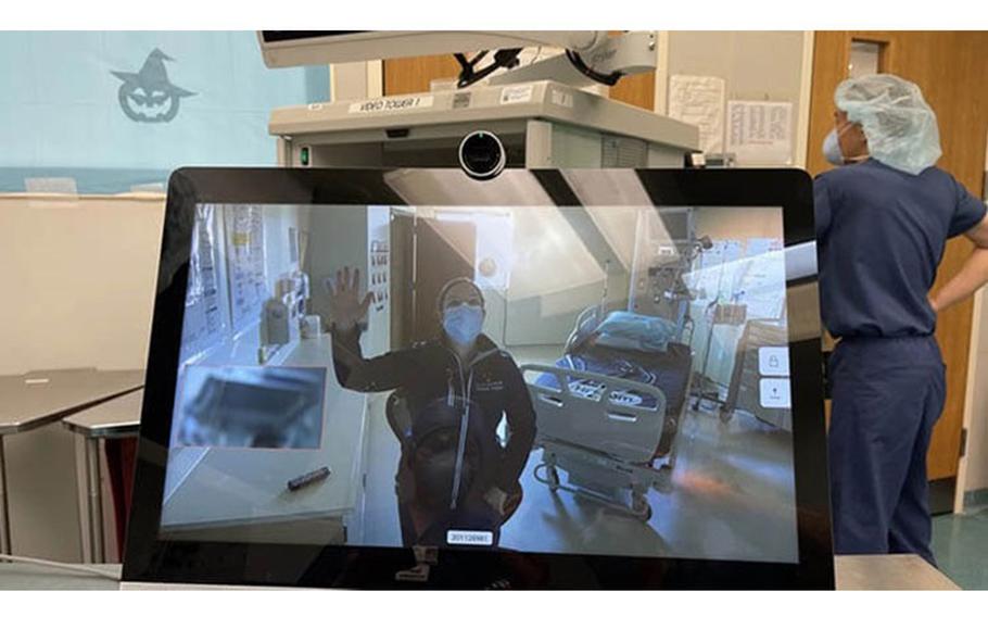 Navy Lt. Cmdr. Kathryn Lipscomb, the urology department head at U.S. Naval Hospital Rota in Spain, waves to staff in USNH Naples, Italy during the first virtual cystoscopy between both hospitals in Jan 2021. (Photo: Navy Cmdr. Ryan Nations)