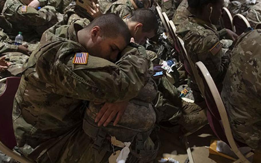 A trainee attempts to get a little sleep as he waits for transportation at the Joe E. Mann Ballroom Dec. 18. He is one of thousands of Initial Entry Training Soldiers across the Army who are headed home on leave for the holidays. (Robert Timmons)