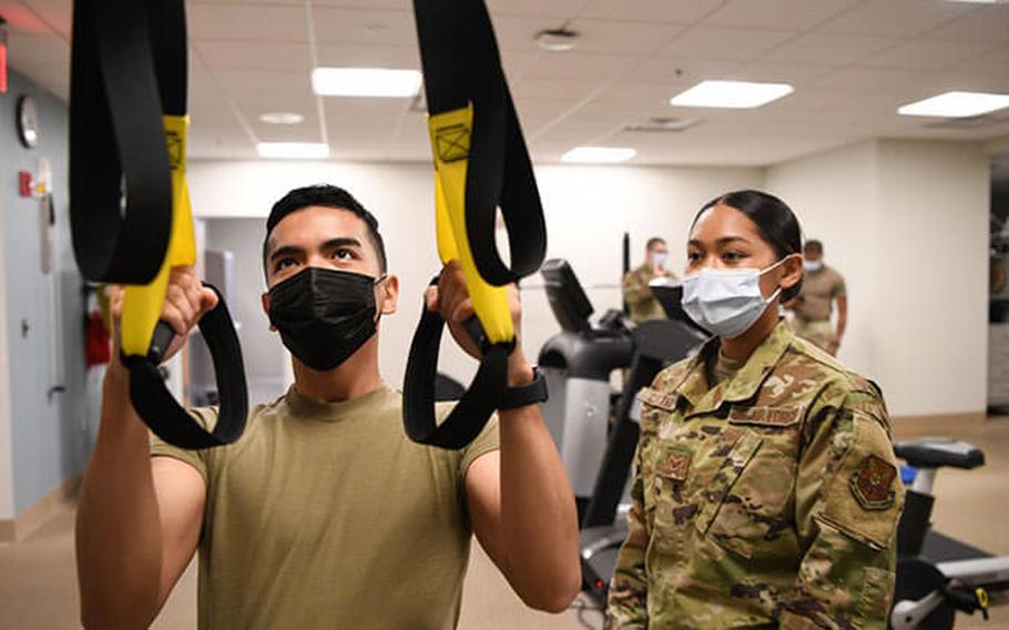 Senior Airman May Cortez, physical therapy technician, assists Airman 1st Class Kyle Maglalang, medical materiel technician, while performing a row on the Total Body Resistance Exercise Training machine, June 24, 2021, in the Medical Clinic at F.E. Warren Air Force Base, Wyoming. The TRX is used for upper body strengthening and stability (Photo by: U.S. Air Force Airman 1st Class Faith Iris MacIlvaine).