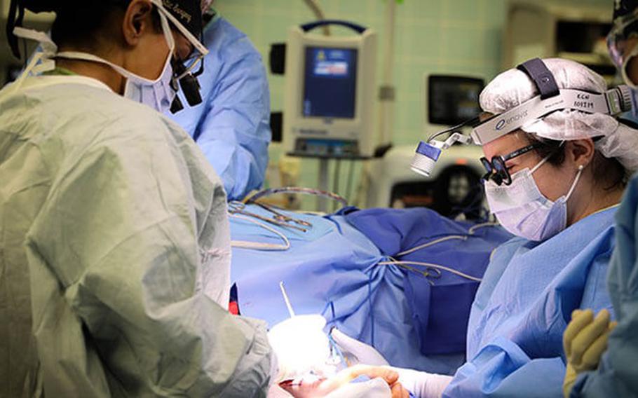 (From left) Army Lt. Col. Shimul Patel, chief, Plastic Surgery Services, Landstuhl Regional Medical Center, and U.S. Army Lt. Col. Jessica Peck, chief, Ear, Nose and Throat Clinic, LRMC, operate on a cancer patient during the first microvascular reconstruction and anastomosis procedure ever performed at LRMC, Dec. 3, 2021. (Photo by Marcy Sanchez)