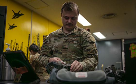 Photo Of U.S. Air Force Senior Airman Kyle Johnson cleans parts of an F-16 Fighting Falcon pilot life preserver unit