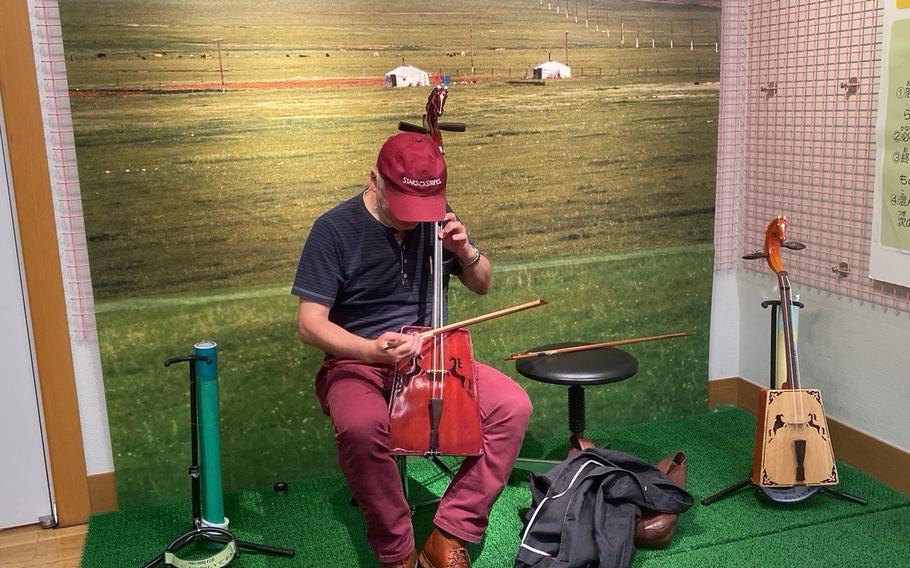 Takahiro tries a Mongolian traditional stringed instrument, “batokin.” 