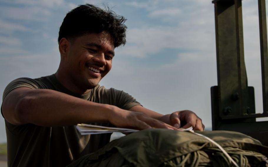 U.S. Air Force Senior Airman Iosaia Lavata’i, 36th Airlift Squadron loadmaster, examines a container delivery system bundle.