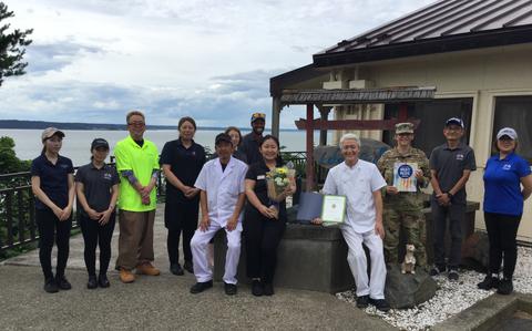 Photo Of Lakeview Grill staff group photo as Stars and Stripes Pacific Commander Lt. Col. Marci Hoffman presents award.