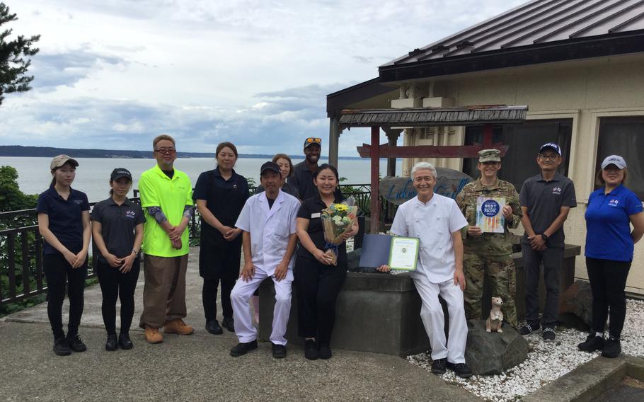 Lakeview Grill staff group photo as Stars and Stripes Pacific Commander Lt. Col. Marci Hoffman presents award.