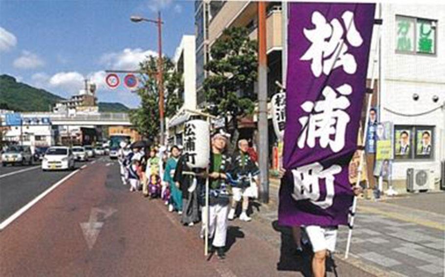 A line of the festival. The person who heads a procession holds a flag.